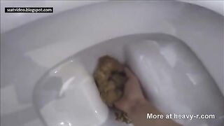 Ein Mädchen rasiert einen großen Haufen Scheiße über der Toilette